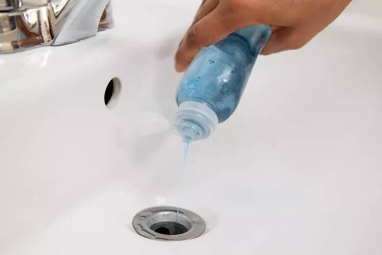 Abfluss mit Backpulver reinigen: Kochendes Wasser und Spülmittel hinzugeben