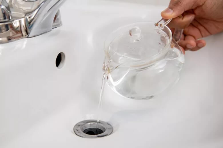 Abfluss mit Backpulver reinigen: Kochendes Wasser hinzugeben